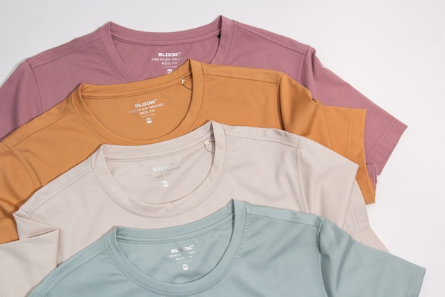Stack of pastel colored cotton t-shirts in soft shades for casual everyday wear